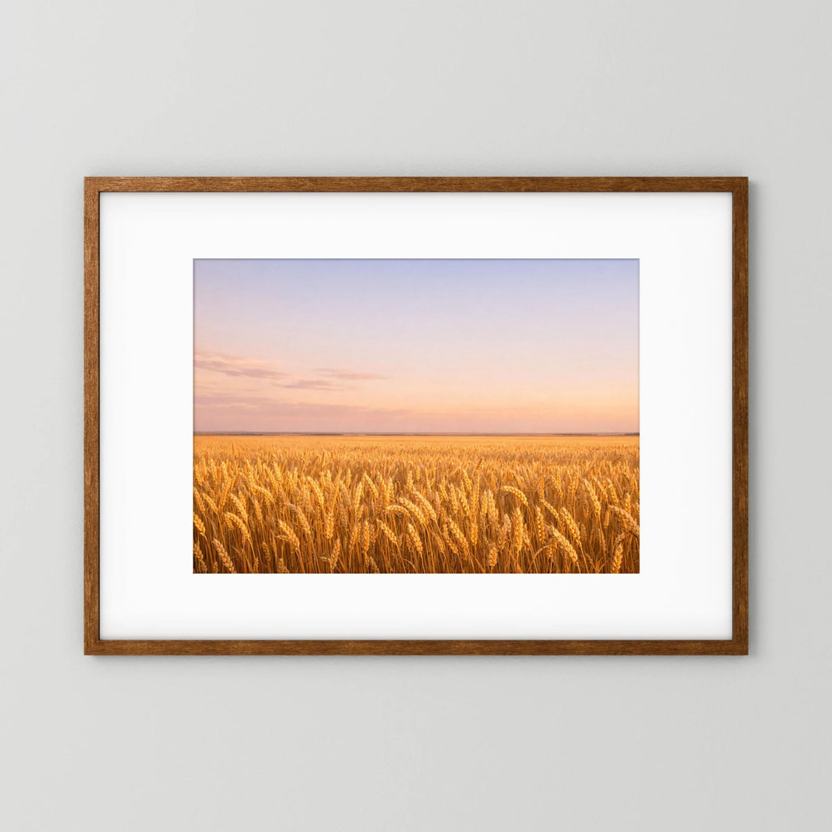 Querformatiges Wandbild mit goldenem Weizenfeld bei Sonnenuntergang im dunklen Holzrahmen