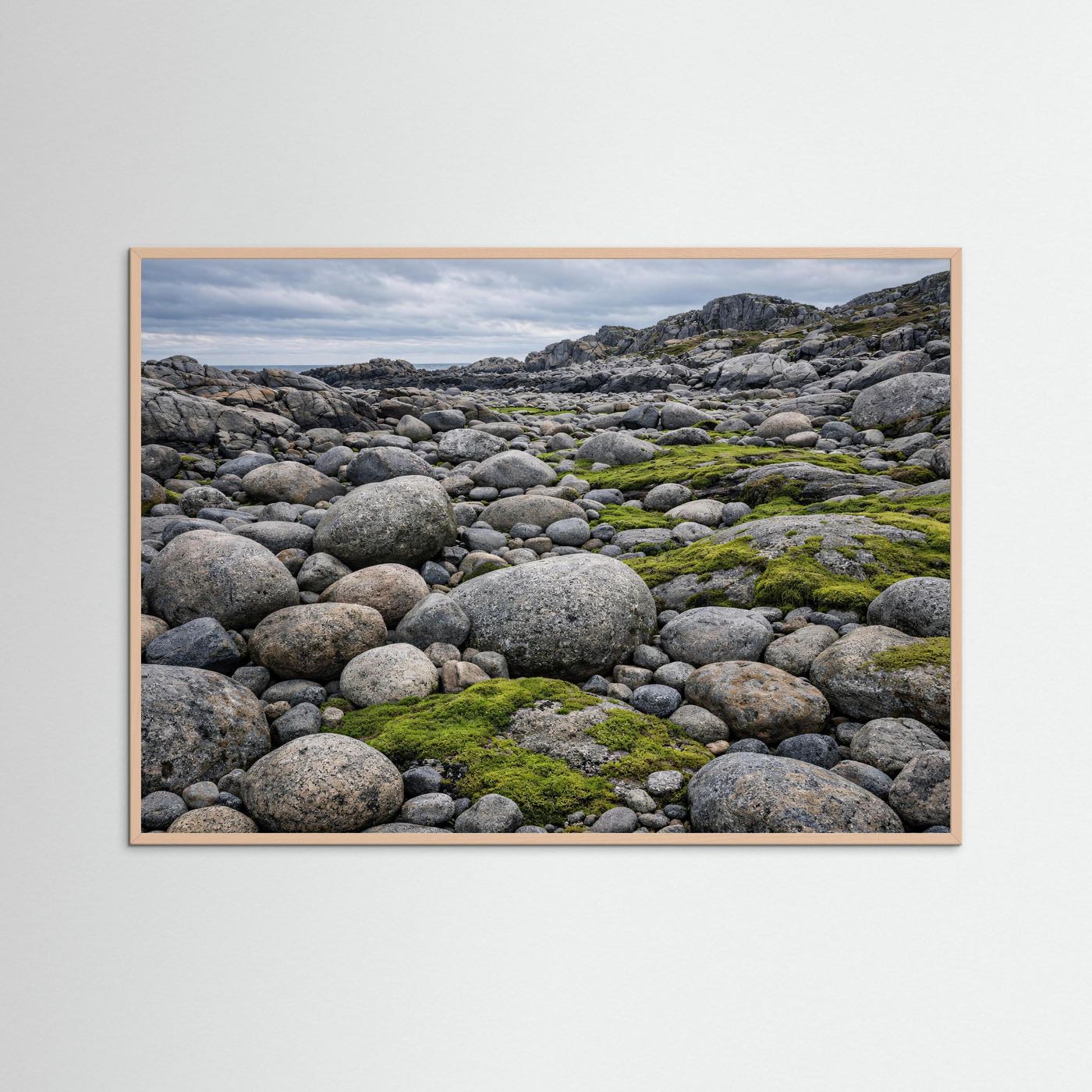 Panorama-Küstenposter mit Holzrahmen: graue Felsbrocken, grünes Moos und Meerblick