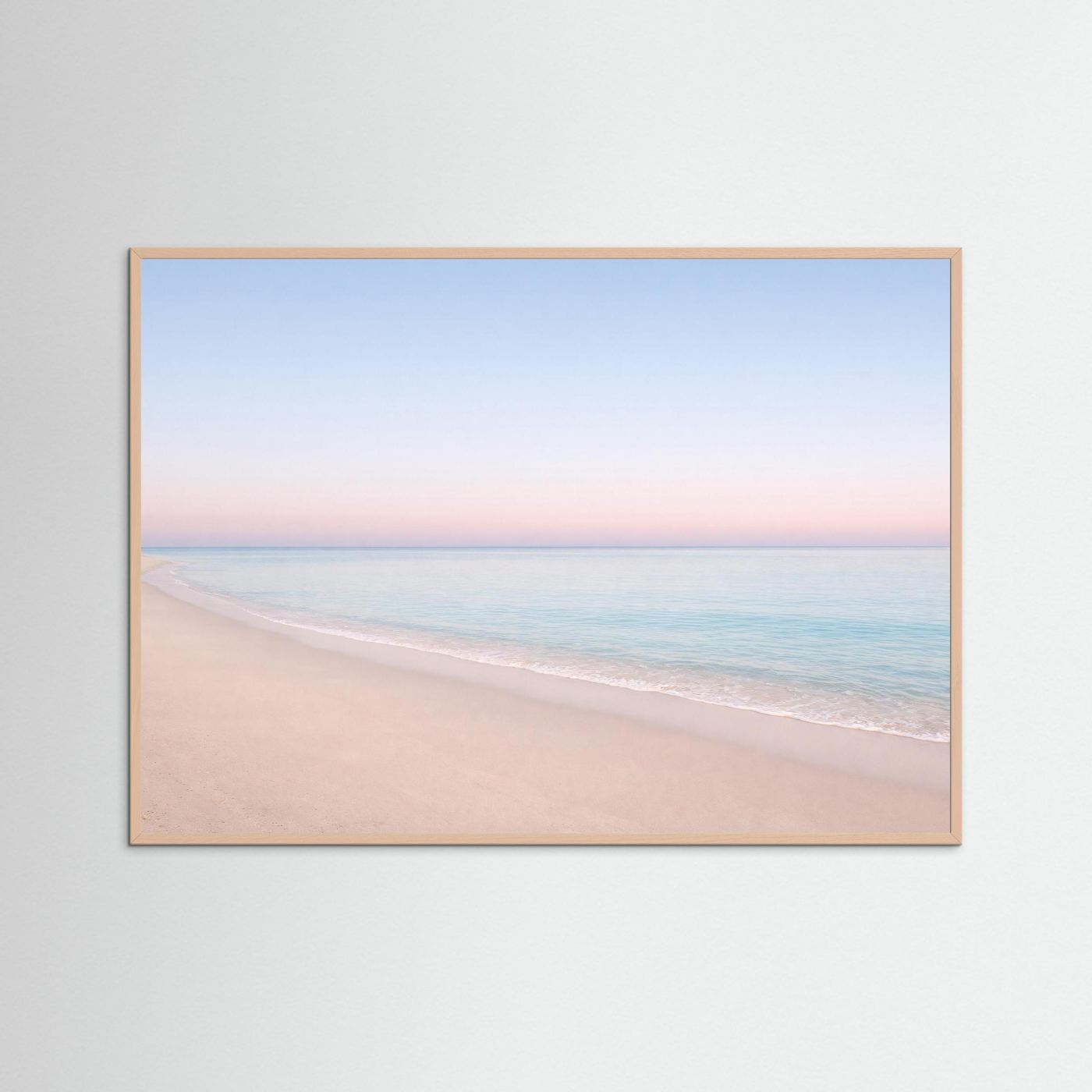 Strandposter im Querformat mit hellem Holzrahmen, Sandstrand und rosa-blauem Himmel