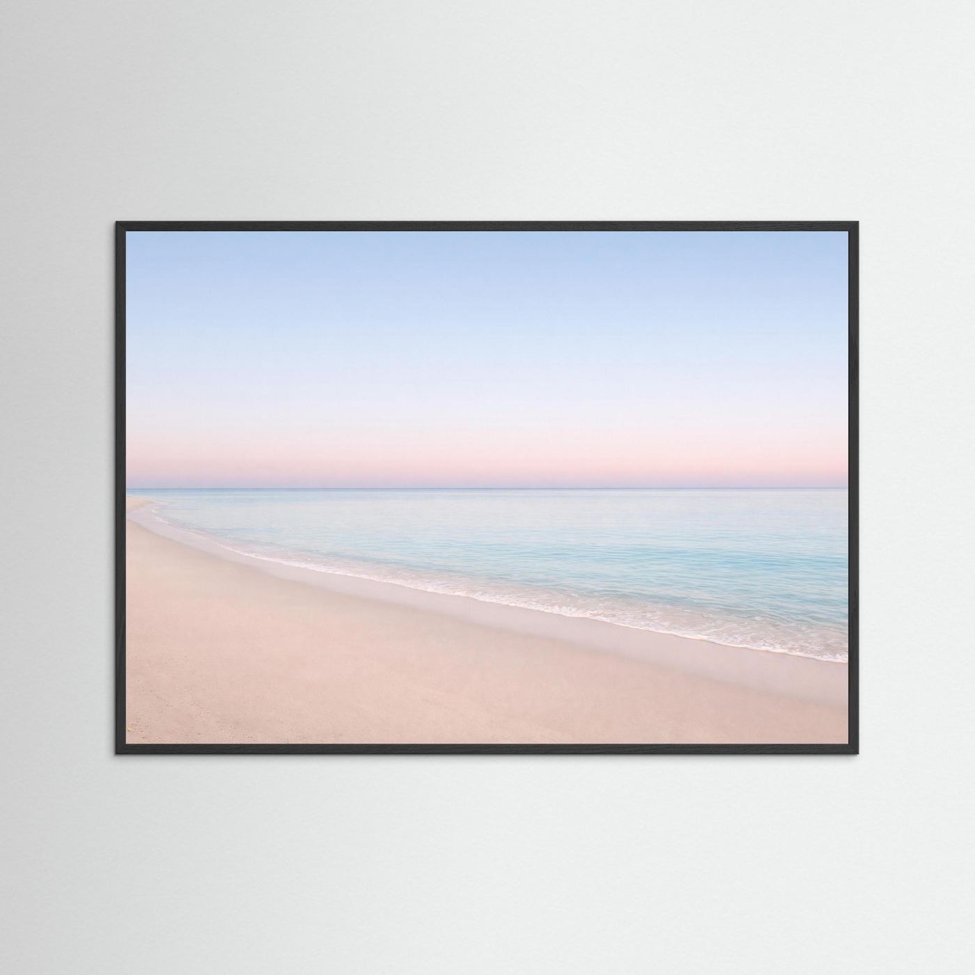 Strandposter im Querformat mit schwarzem Holzrahmen, hellem Sand und rosa-blauem Himmel