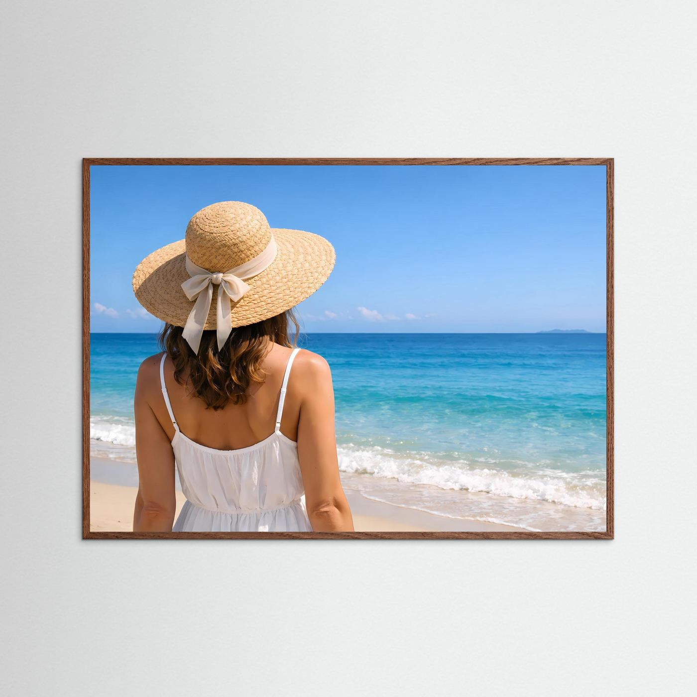 Strandposter im Querformat mit braunem Holzrahmen: Frau mit Strohhut und weißem Kleid