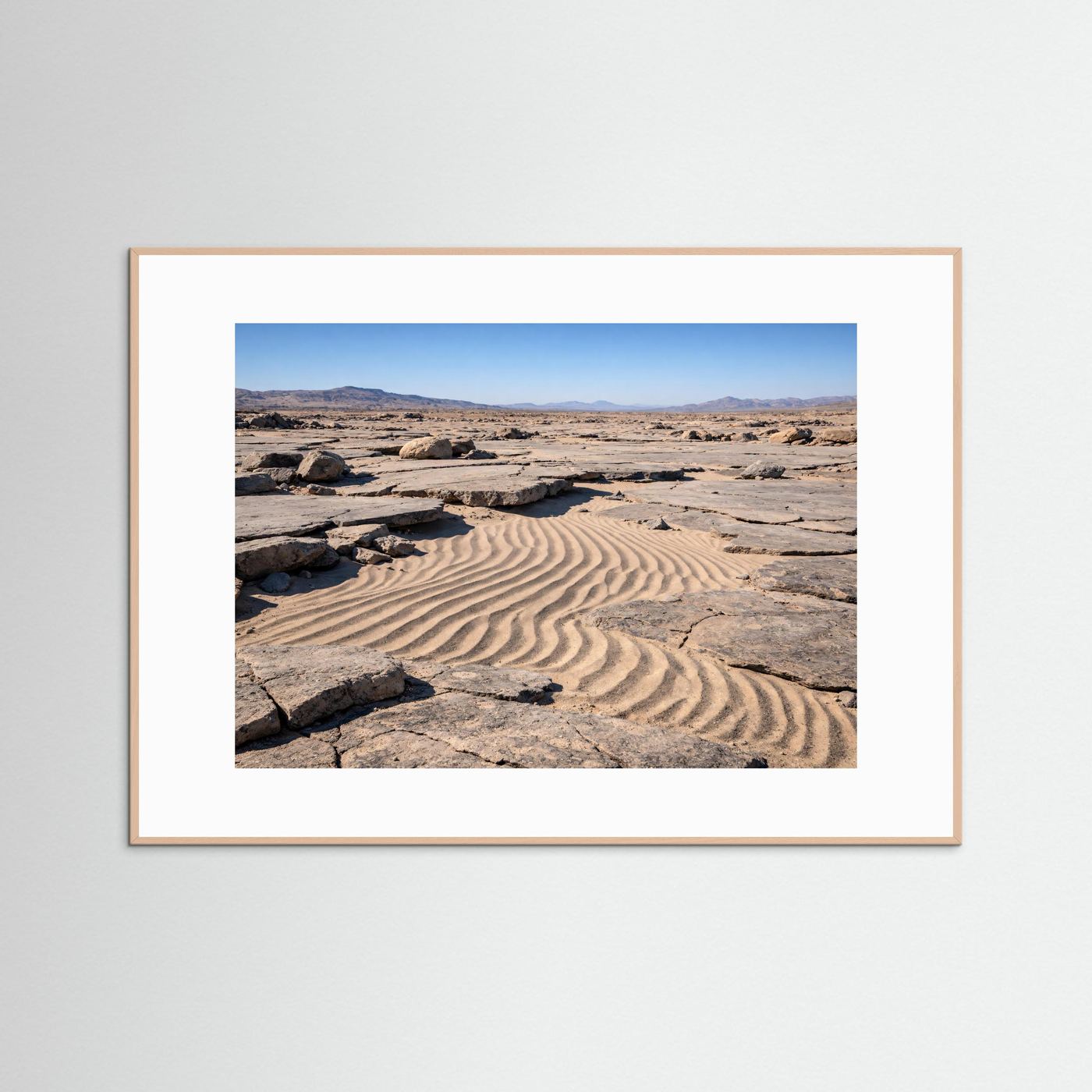 Naturposter im rosafarbenem Holzrahmen: Sanddünen, Felsbrocken und Berghorizont