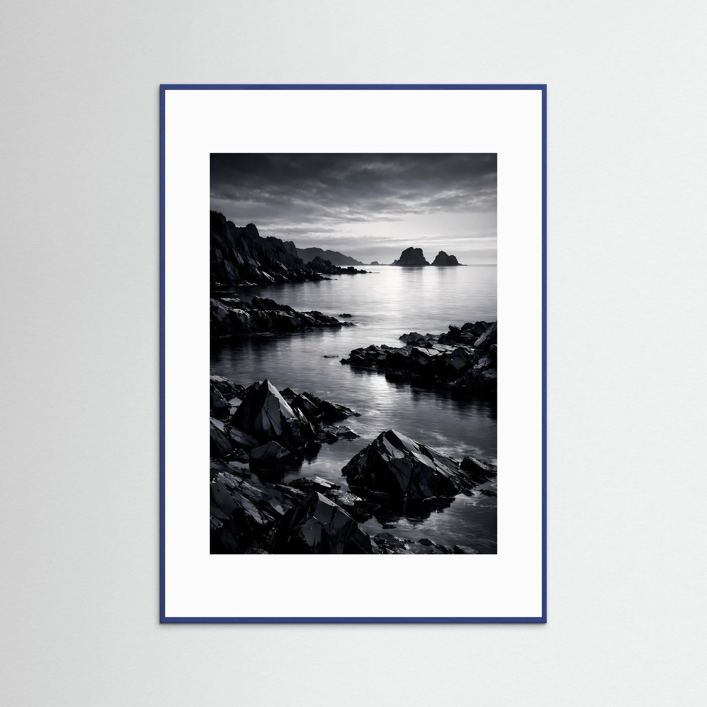 Wandbild Schwarz-Weiß-Küste mit Felsen am Meer, Insel in der Ferne; blau eingefasst