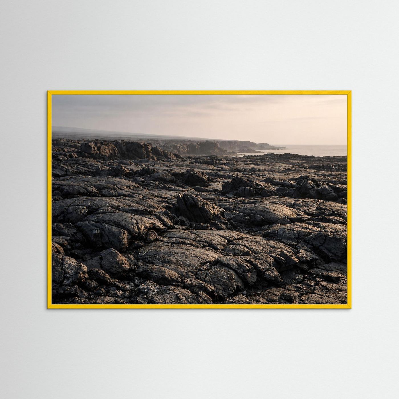 Wandbild mit gelbem Rahmen: Lavafelder an der Küste, schwarze Küstenvulkane