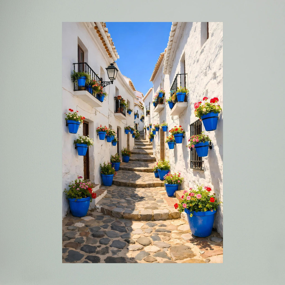 Wandbild im Hochformat mit andalusischer Straße, blauen Blumenkübeln und bunten Blumen