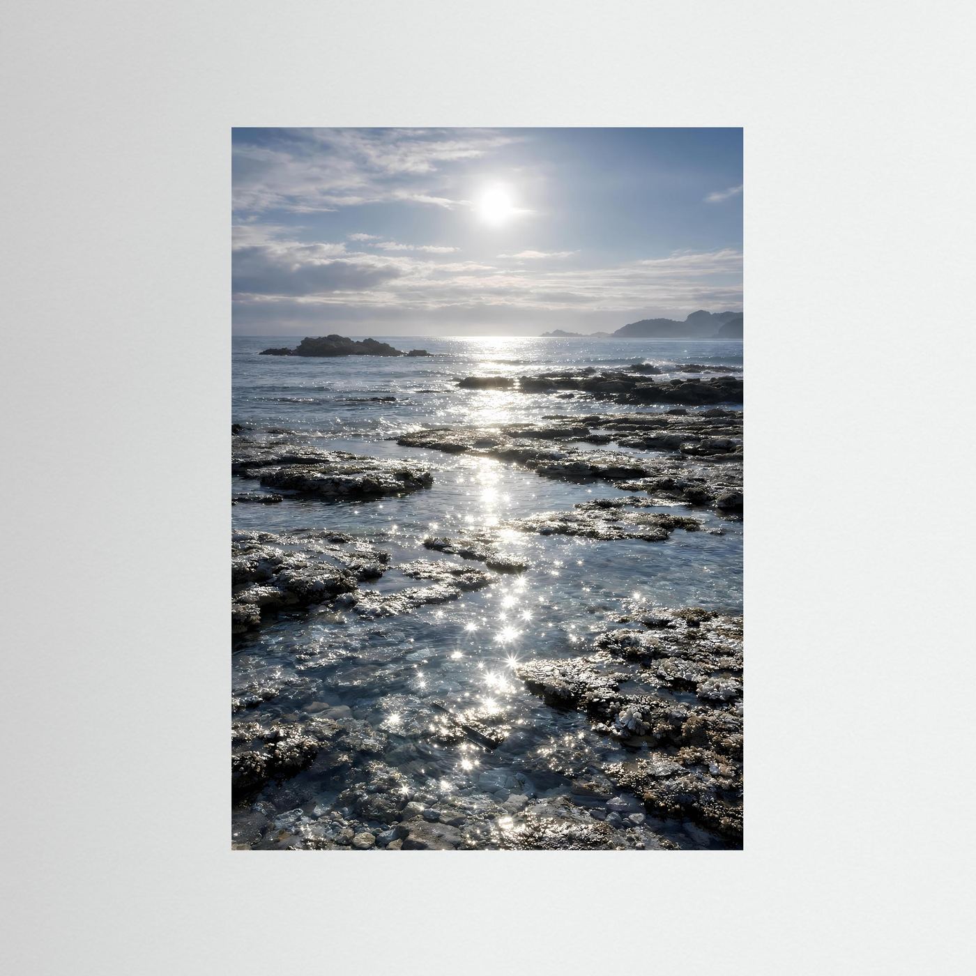Hochformatiges Küstenposter mit Felsen, Meeresspiegeln und Sonnenreflexen