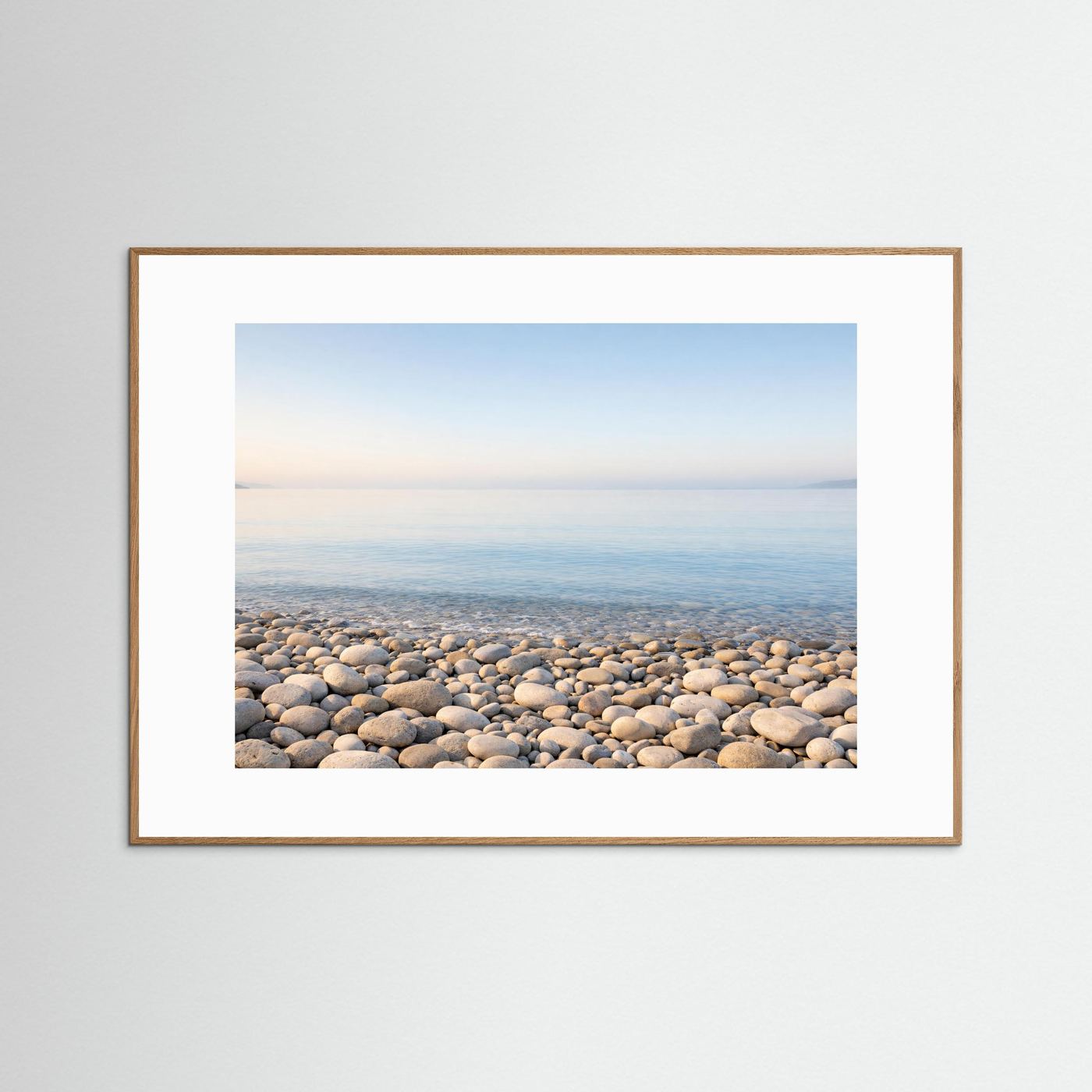 Küsten-Panorama-Poster mit Kiesstrand und ruhigem Meer, naturbrauner Rahmen