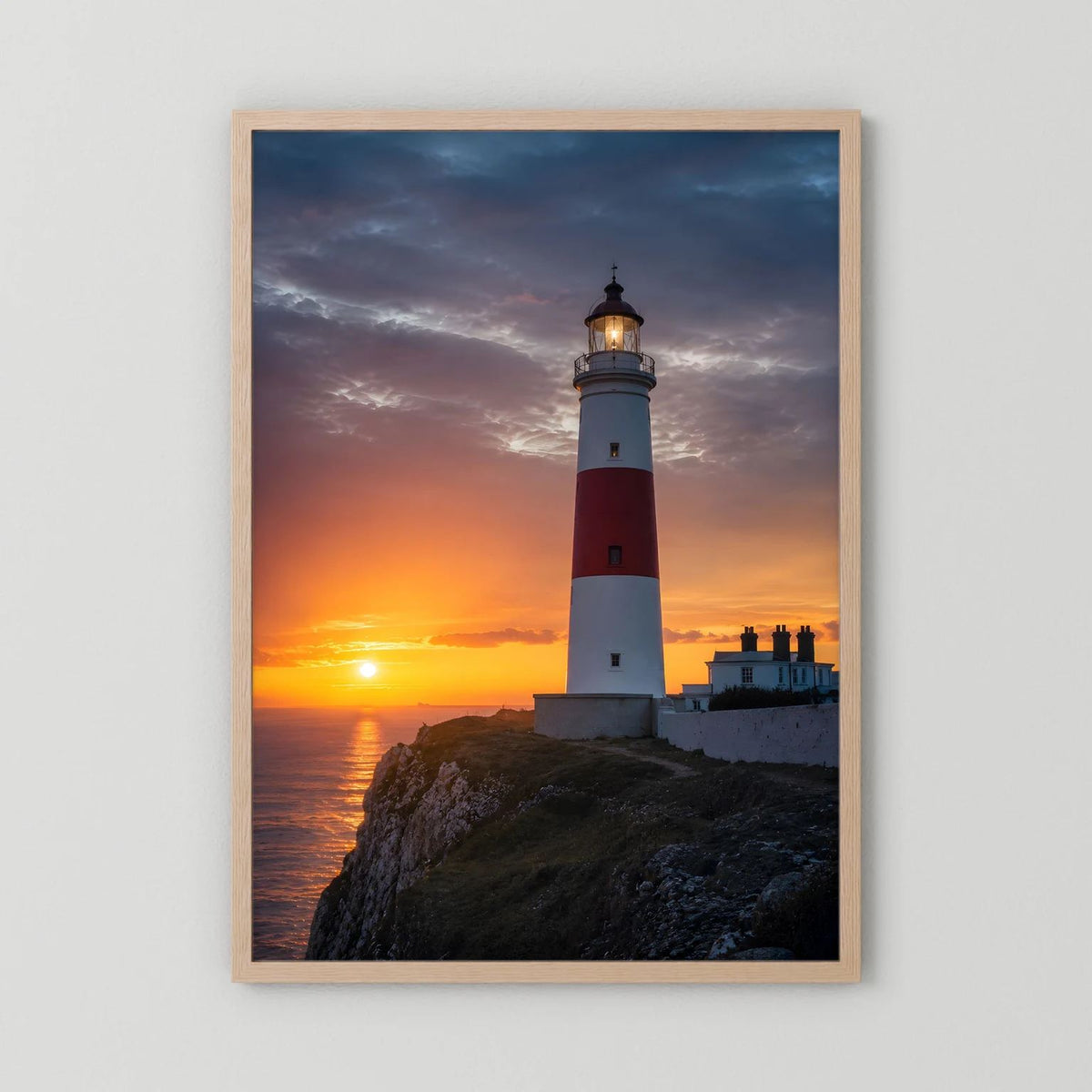 Wandposter mit Leuchtturm am Meer bei Sonnenuntergang, Holzrahmen