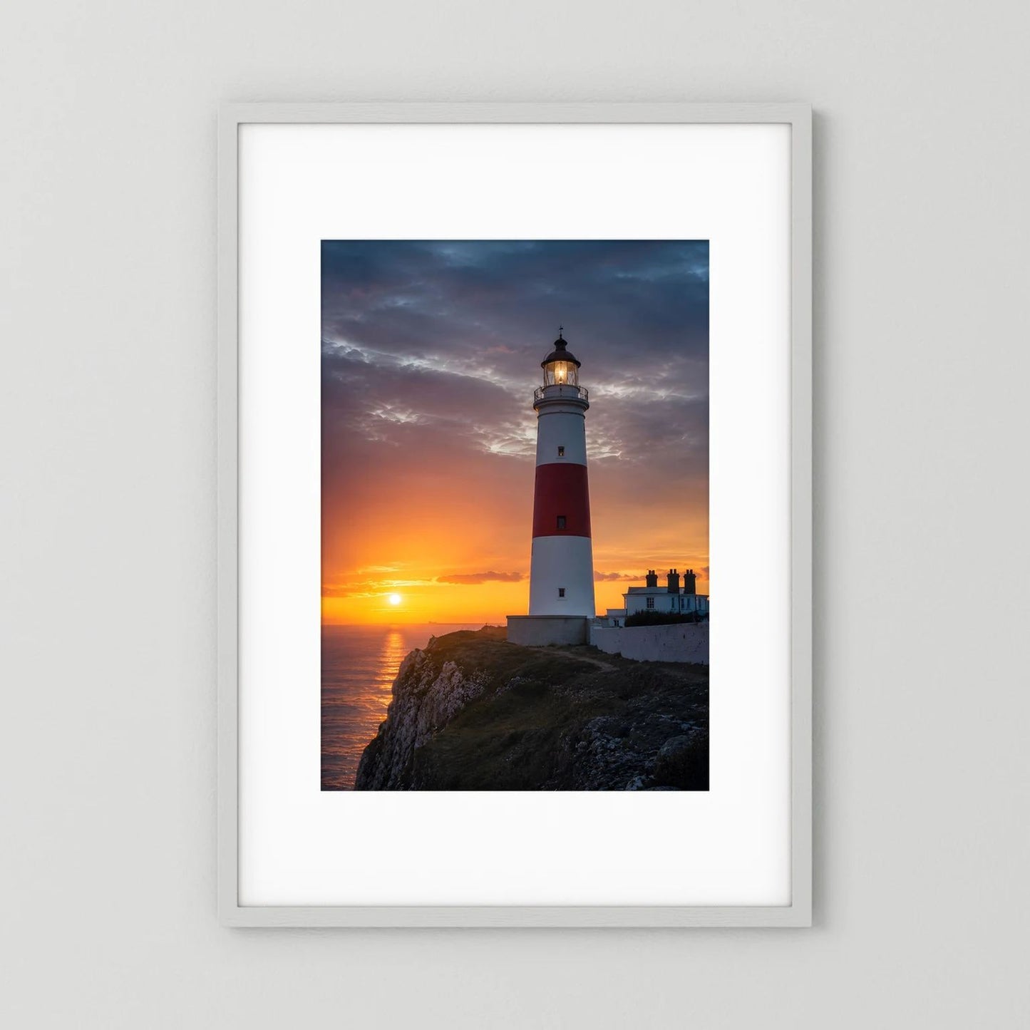 Wandposter im Hochformat mit Leuchtturm an der Küste bei Sonnenuntergang