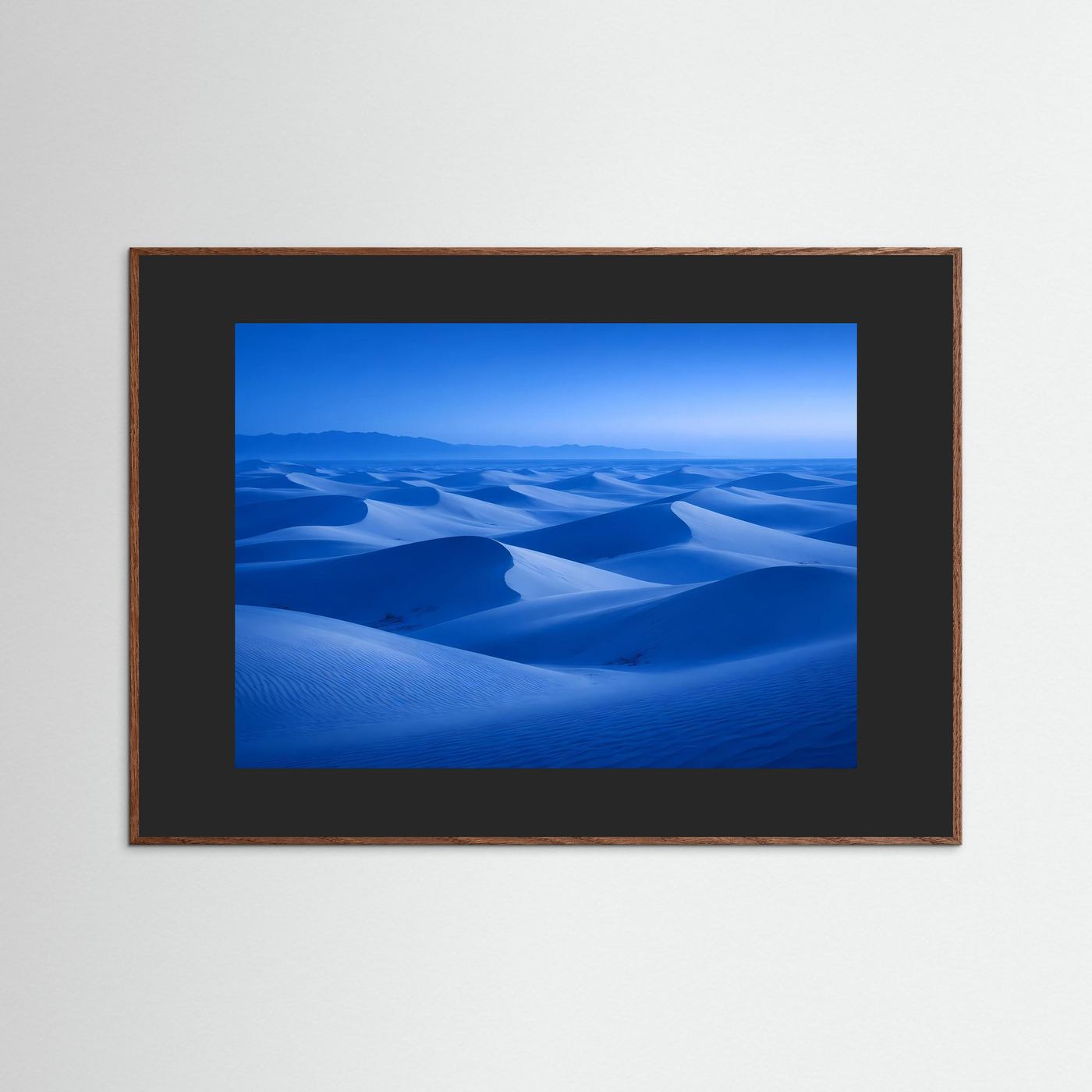 Wandbild mit blauem Dünenlandschaft-Motiv im braunen Rahmen