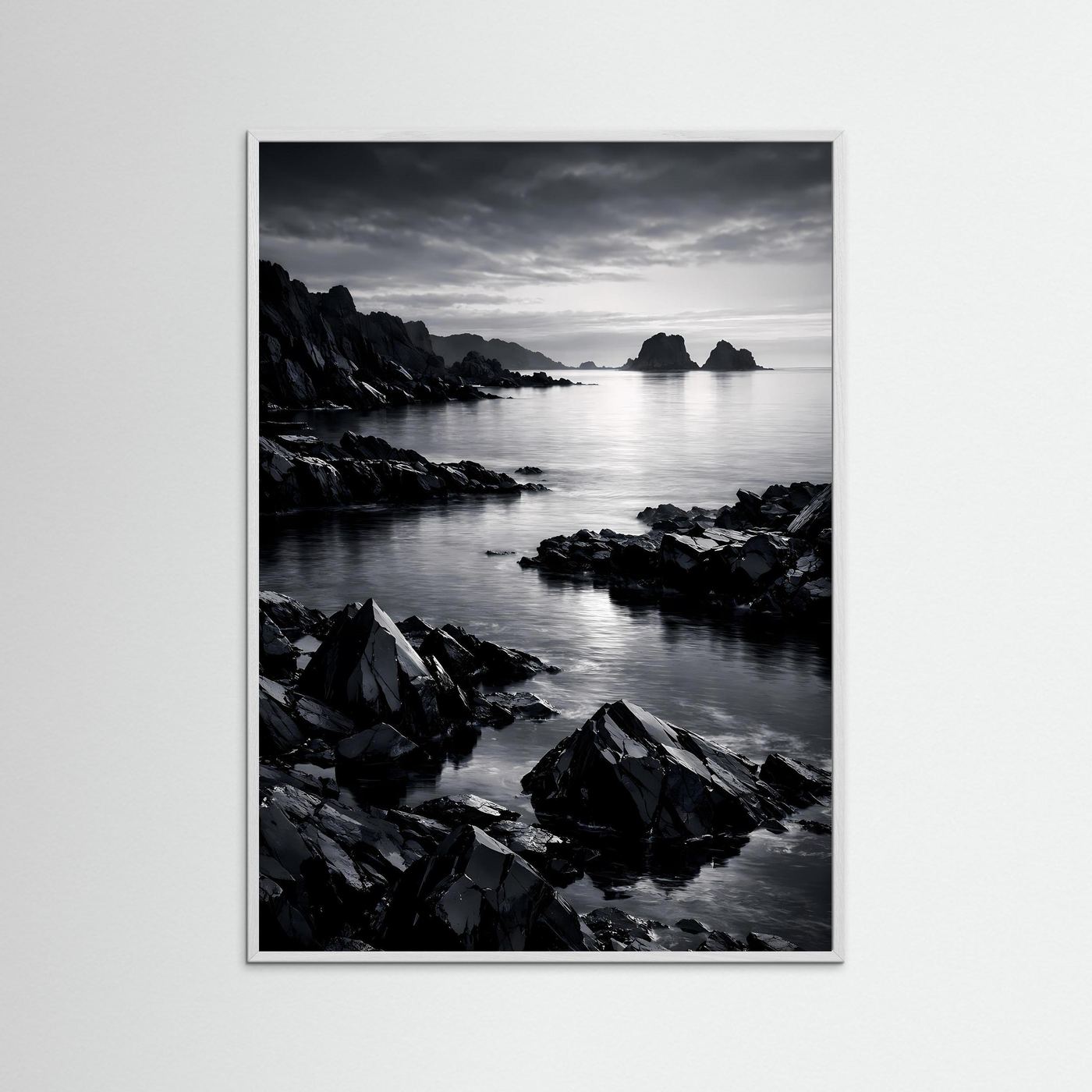 Wandbild Schwarz-Weiß-Küste mit Felsen am Meer, ruhiges Wasser; silberner Rahmen