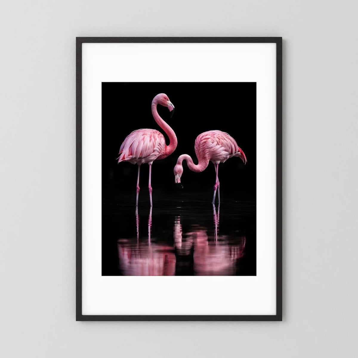 Hochformatiges Poster mit zwei rosa Flamingos im schwarzen Rahmen; schwarze Fläche mit Spiegelung