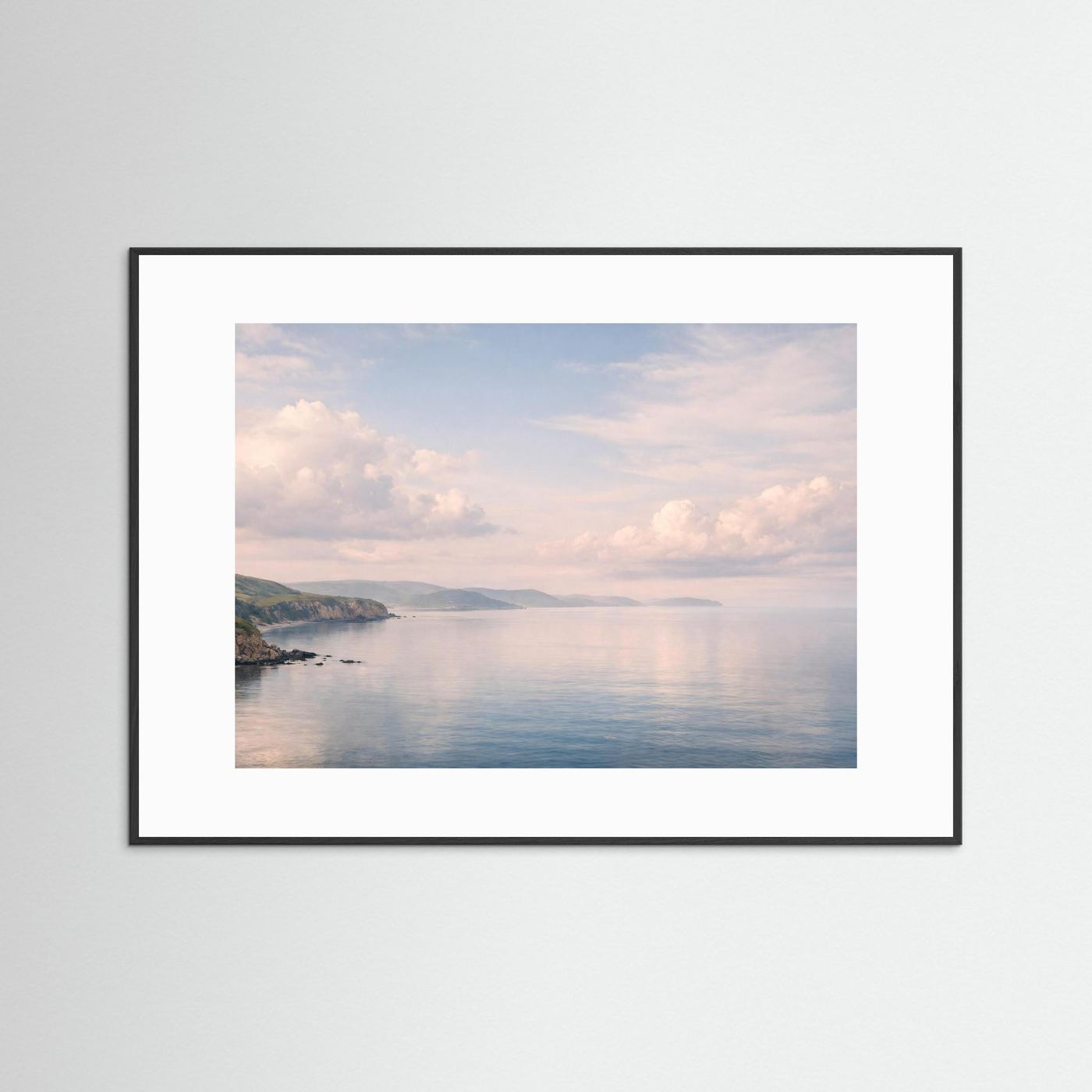 Panorama-Meerposter im Querformat mit schwarzem Rahmen und weißem Rand: Küste, Wasser, Wolken