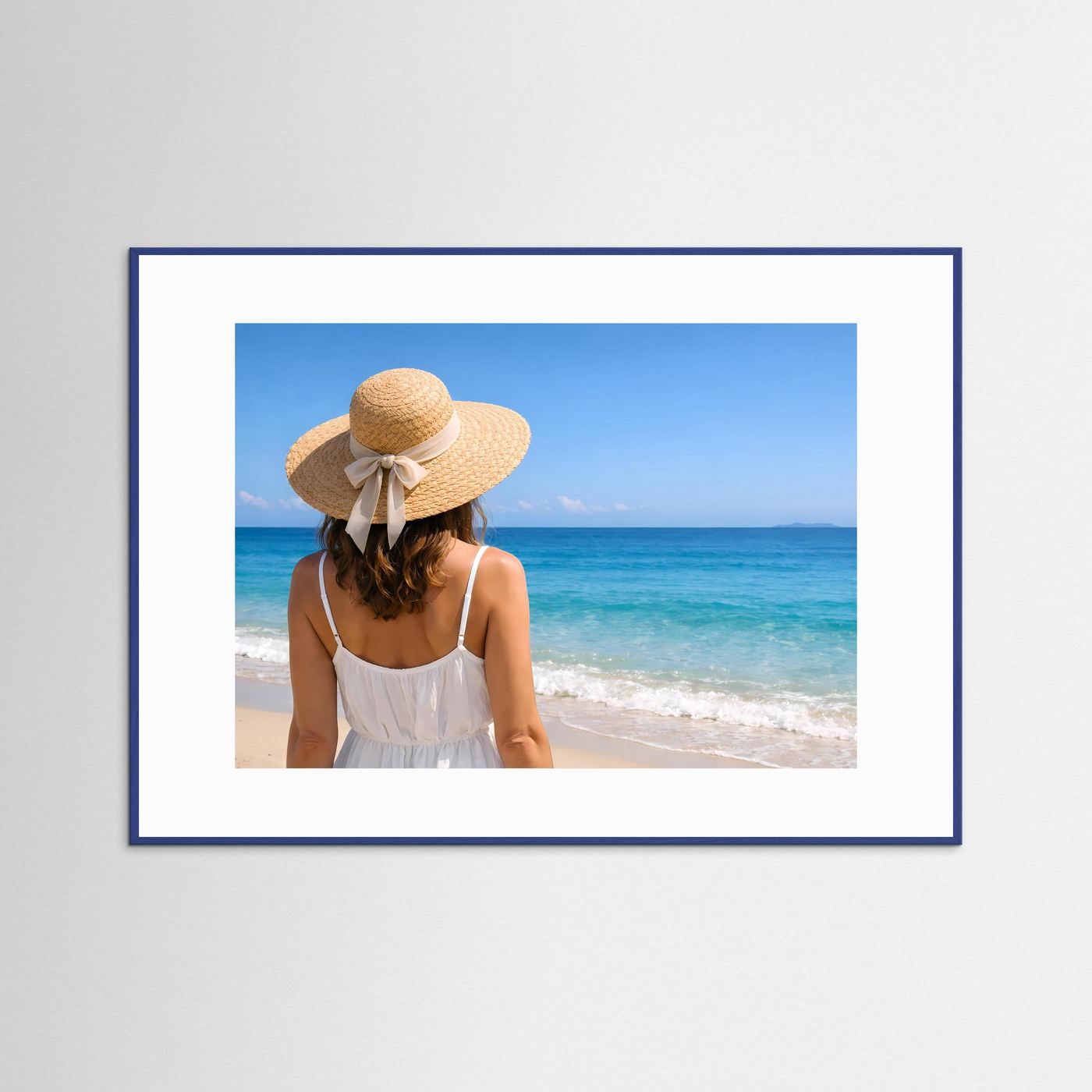 Strandposter mit blauem Rahmen: Frau im weißen Kleid, Strohhut, Meerblick