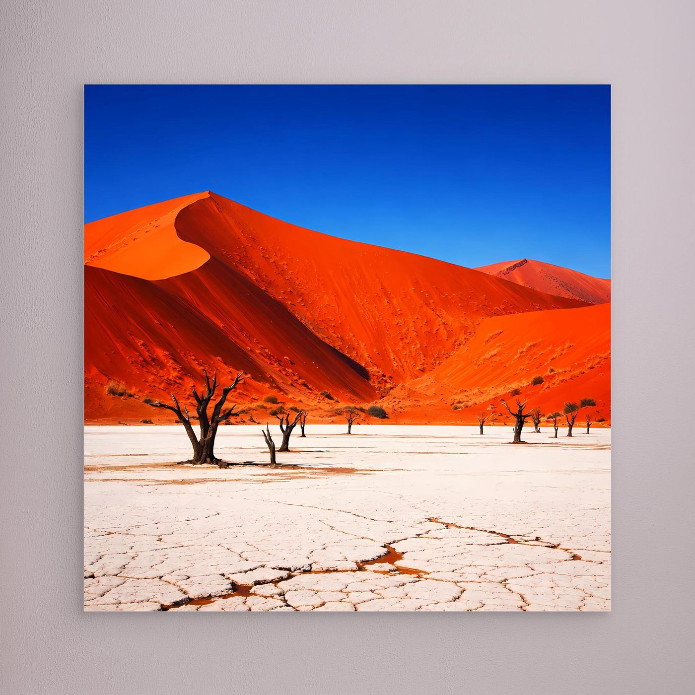 Leinwandbild mit roten Dünen, Rissboden und vereinzelten Bäumen vor blauem Himmel.