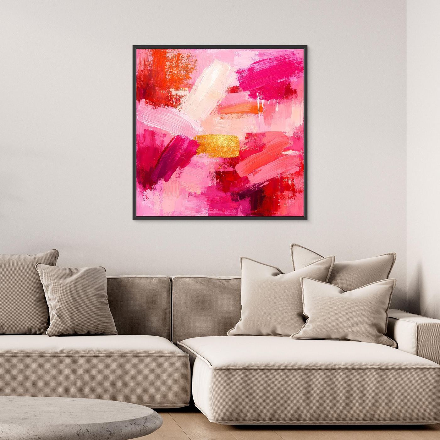 Abstract canvas wall art with pink and rose brushstrokes and small gold accents in black frame.