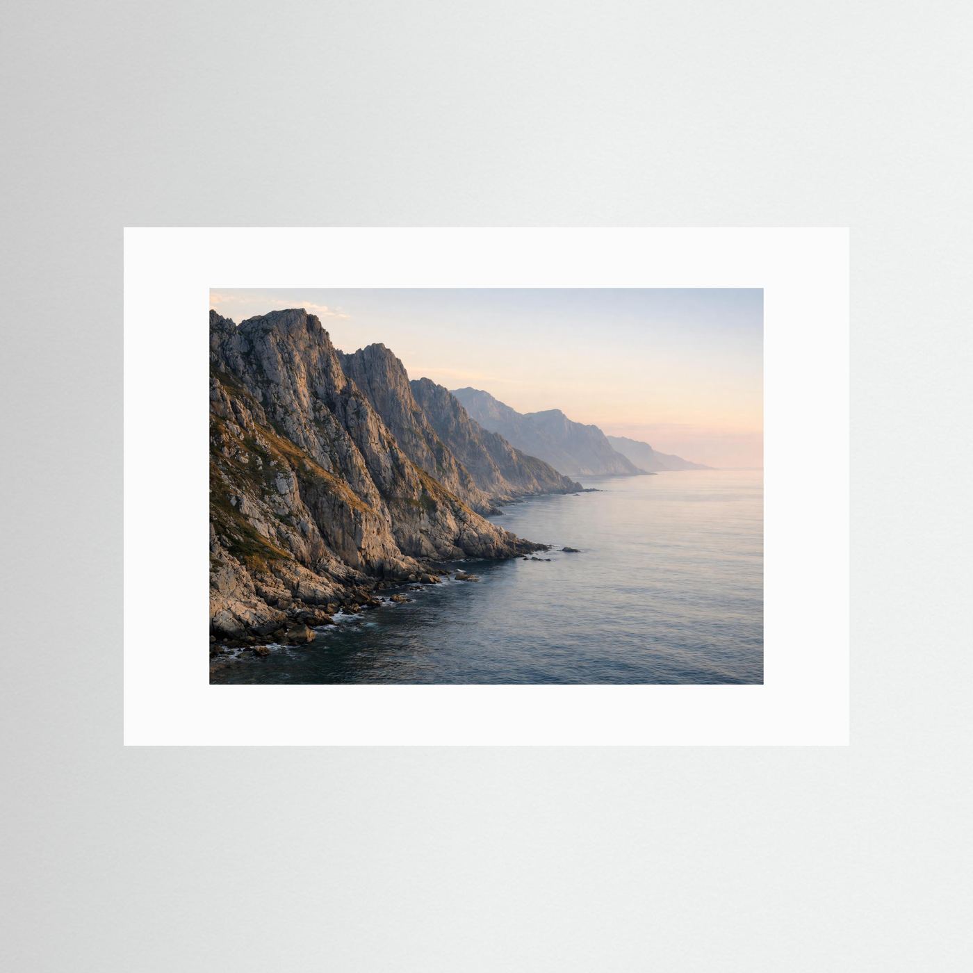 Poster im Querformat mit weißem Passepartout: Panorama-Felsküste am Meer im Abendlicht