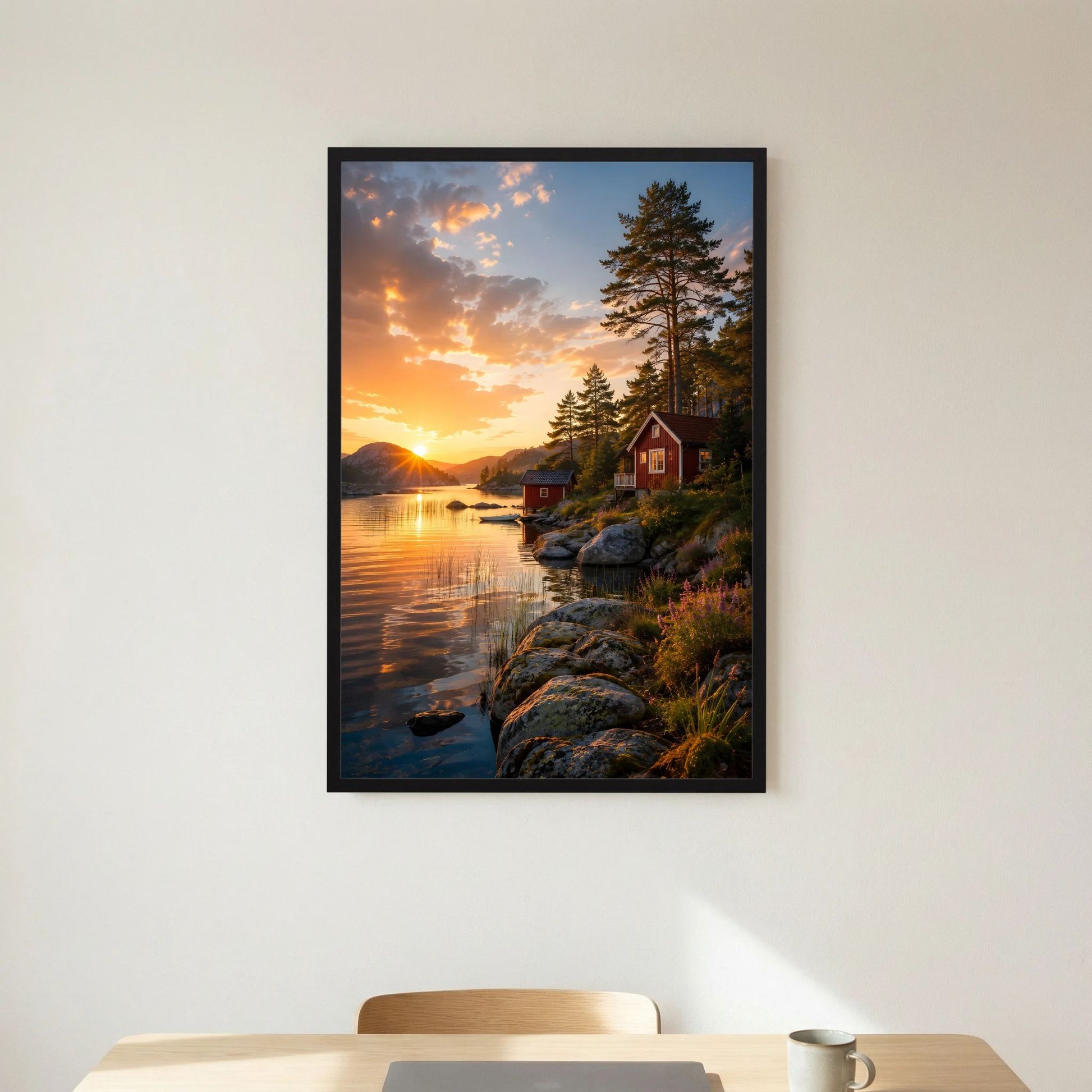 Kunstposter im Hochformat mit schwarzem Rahmen: Uferfelsen am See, Sonnenuntergang, rote Hütte.