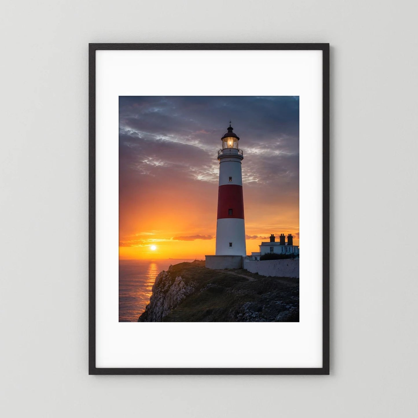 Wandposter mit Leuchtturm am Meer bei Sonnenuntergang, schwarzer Rahmen mit weißer Einfassung