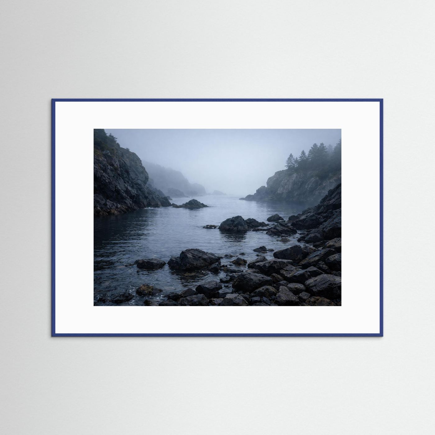 Naturposter Querformat mit blauem Rahmen: neblige Felsenküste am Meer, Felsen und Wasser