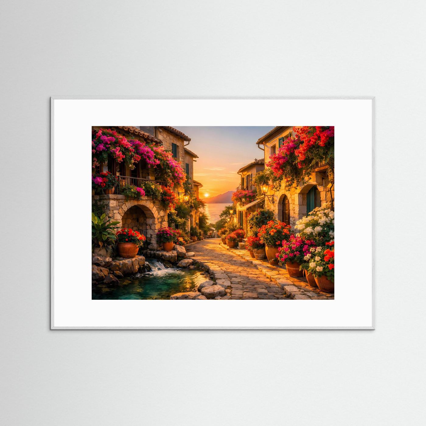 Wandposter mit mediterraner Gasse, blühenden Büschen und kleinem Bach, weiß gerahmt.