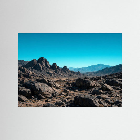 Naturposter Querformat mit felsiger Wüstenlandschaft und blauem Himmel