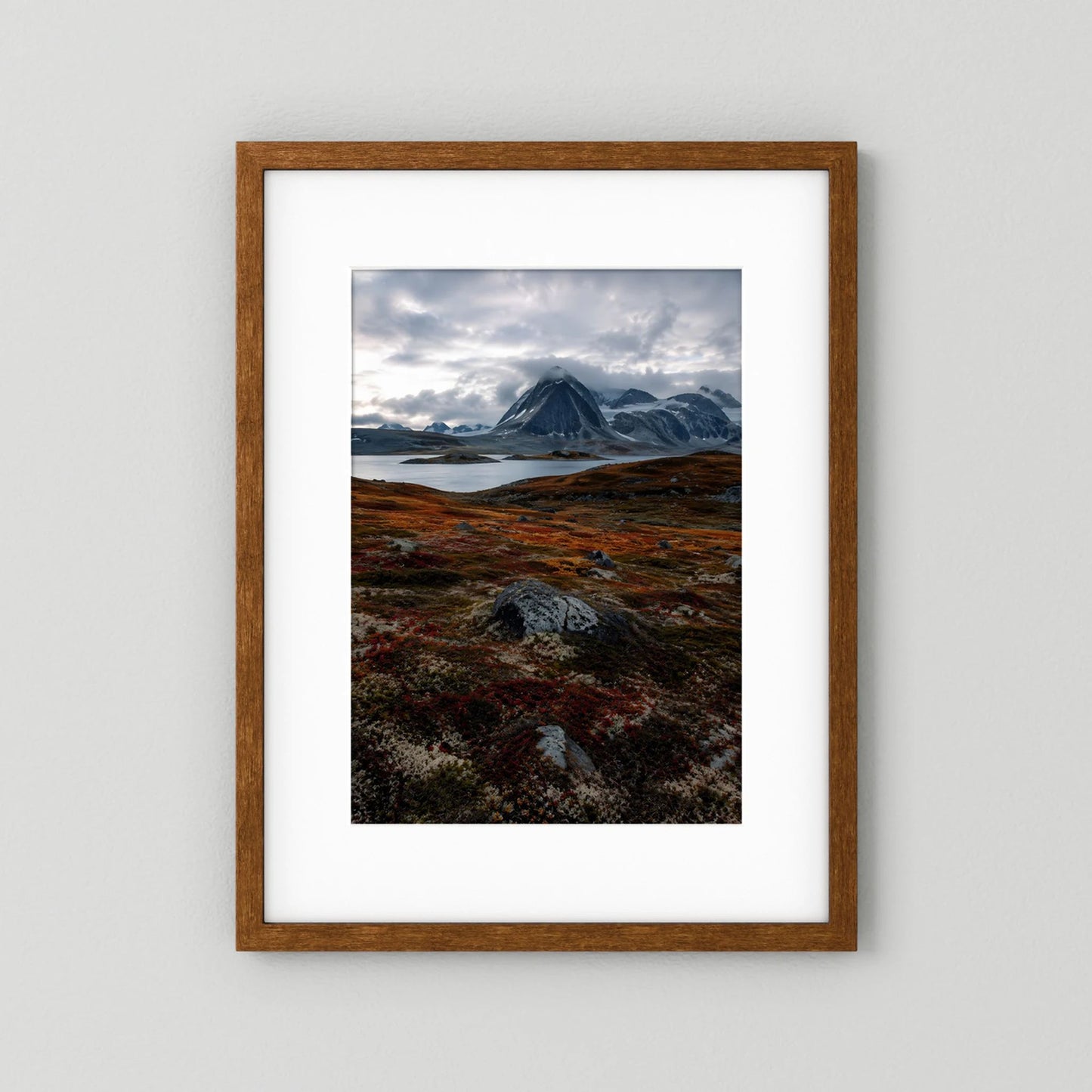 Naturposter im Hochformat mit dunklem Holzrahmen: Berglandschaft in Grau und Rostrot