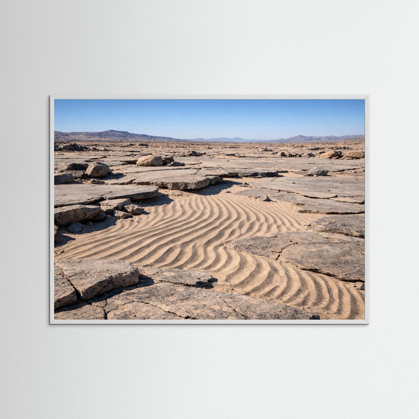 Naturposter im Querformat mit silberfarbenem Rahmen: Sanddünen und Felsbrocken in der Wüste