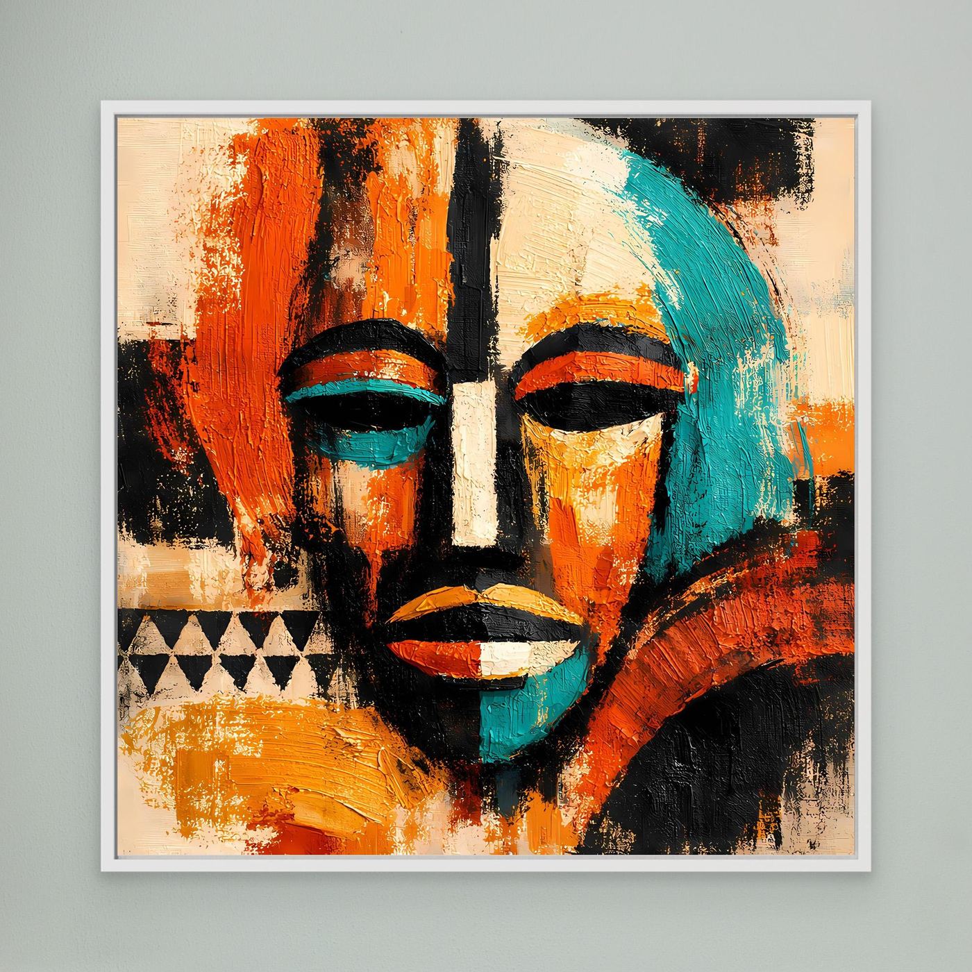 Framed abstract mask portrait wall art, teal and orange faces with black accents.
