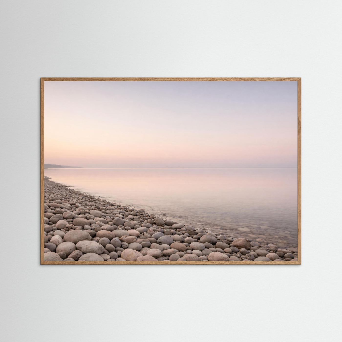 Panorama-Poster Kiesstrand und Meer im Pastelllicht, heller Eichenrahmen