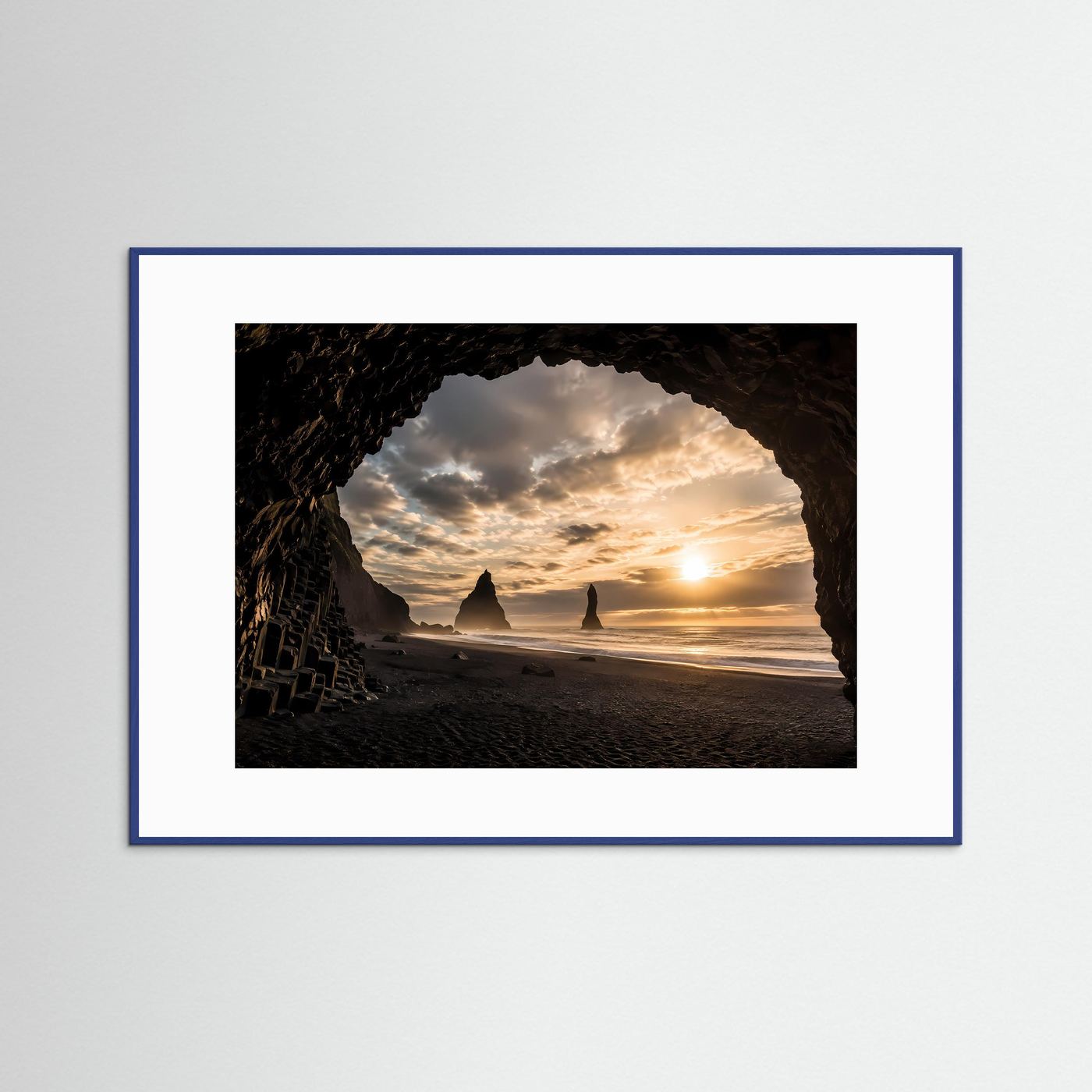 Querformatiges Poster: Felsbogen am schwarzen Sandstrand im Sonnenuntergang, blau gerahmt