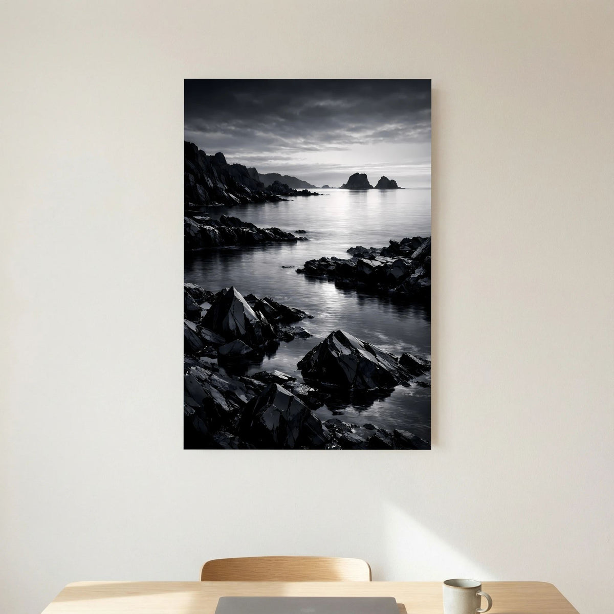 Hochformatiges schwarzweißes Wandbild mit Felsen an der Küste und Wasserfläche