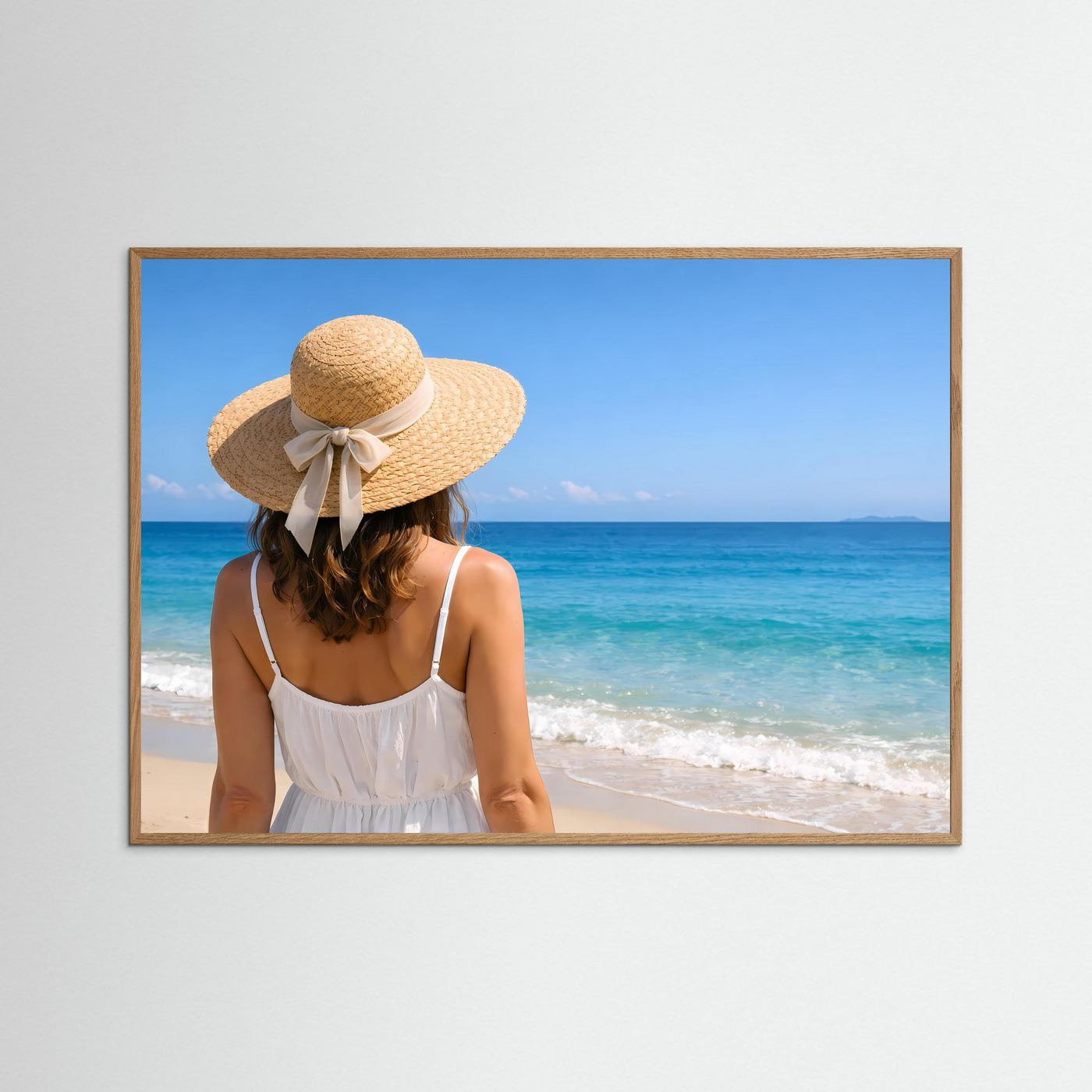 Strandposter im Querformat mit braunem Holzrahmen: Frau mit Strohhut und weißem Kleid