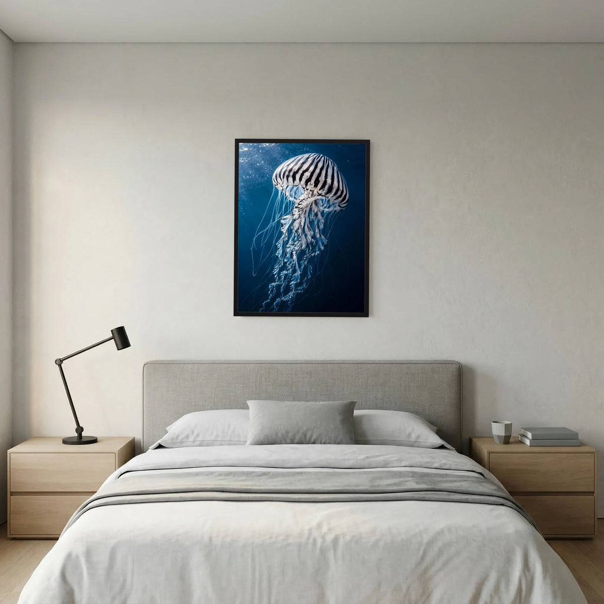 Hochformatiges Poster mit Qualle in Blau über dem Bett, schwarzer Rahmen
