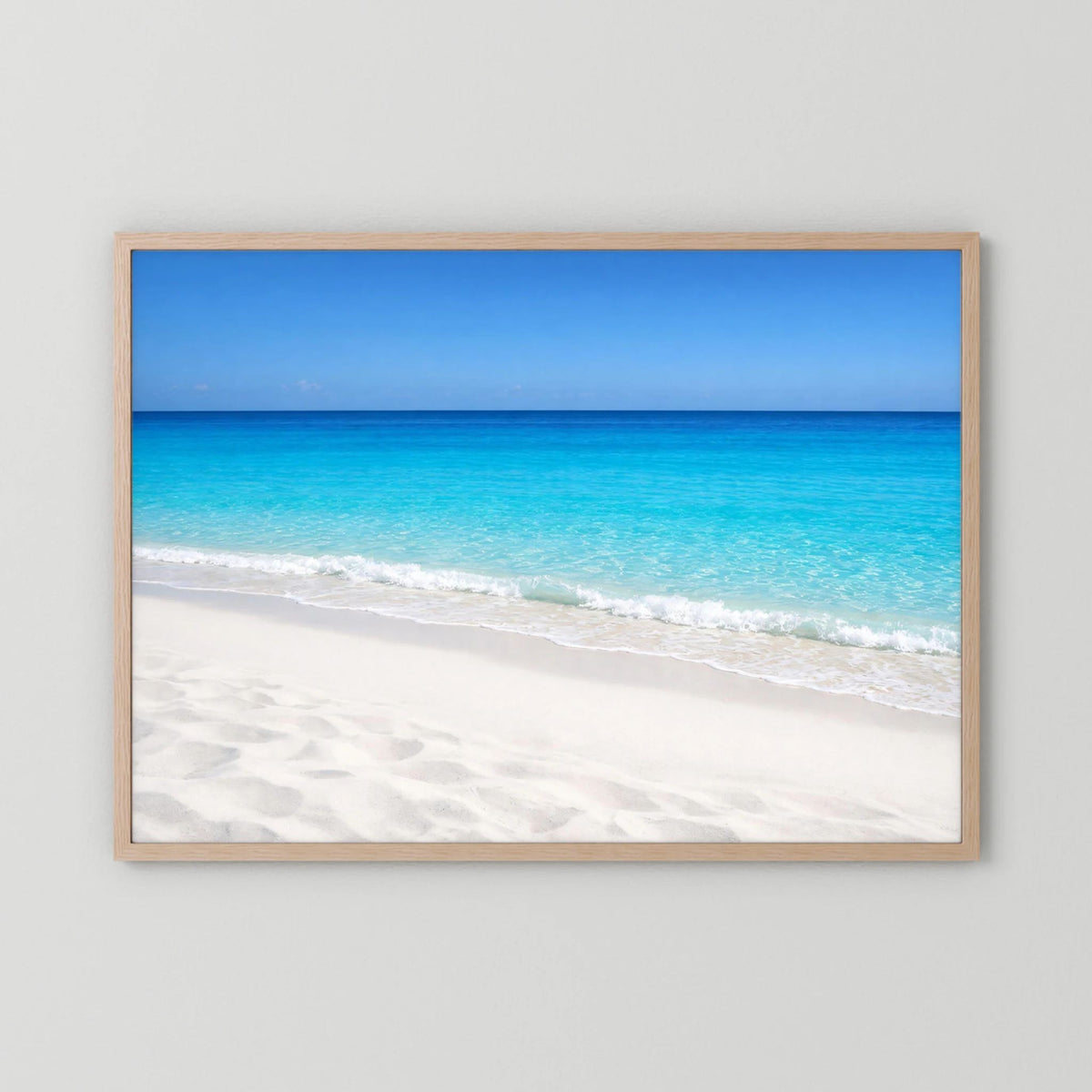 Querformat-Wandbild im hellen Holzrahmen: türkisblaues Meer und Sandstrand