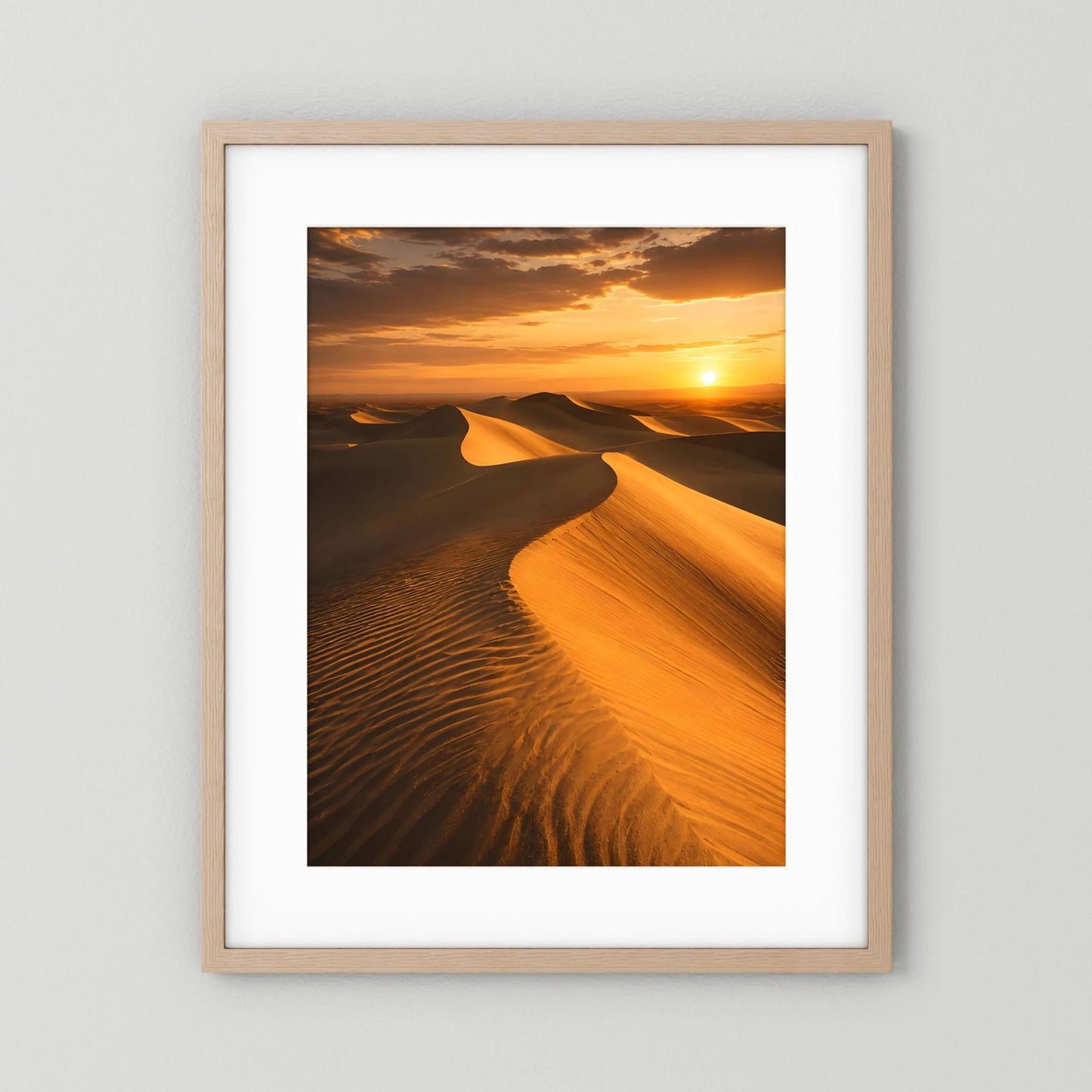 Poster mit Sanddünen und Orange-Sonnenuntergang, heller Holzrahmen mit weißem Rand