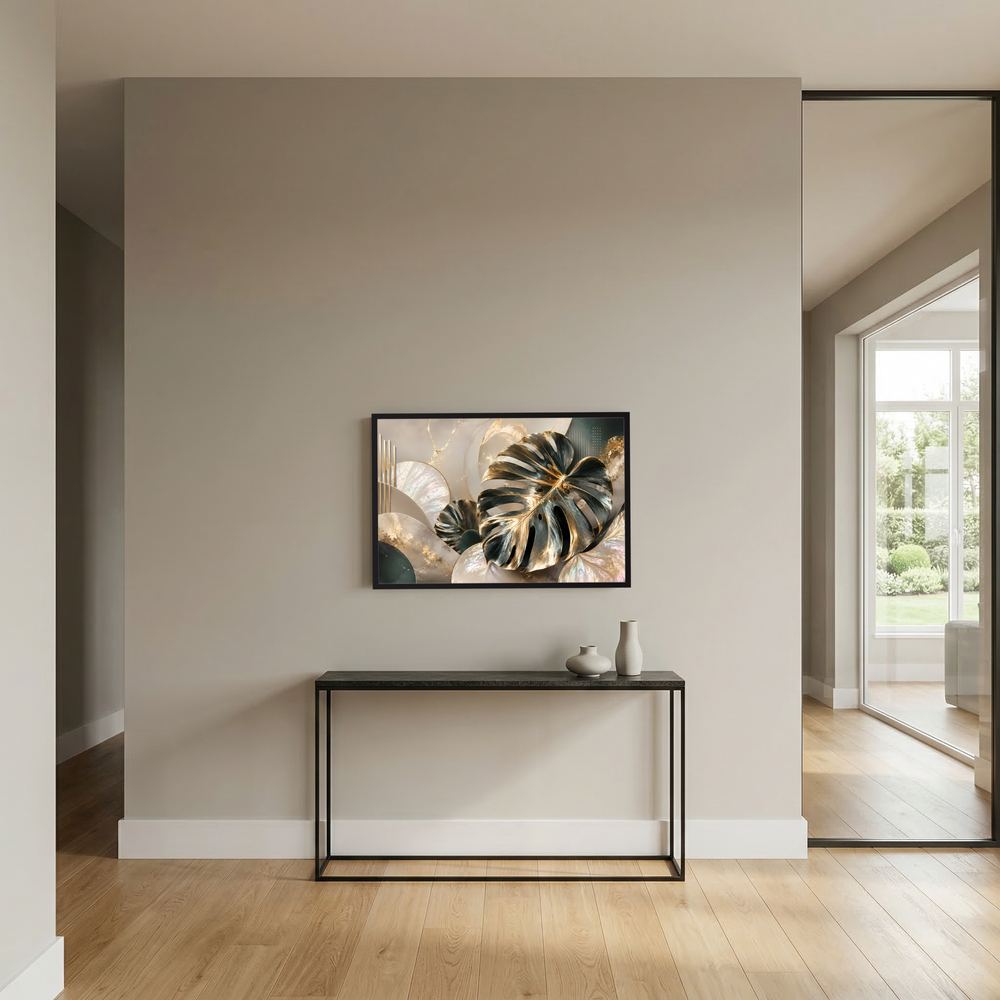 Wandposter mit goldenen Monstera-Blättern auf cremefarbenem Hintergrund, schwarzer Rahmen