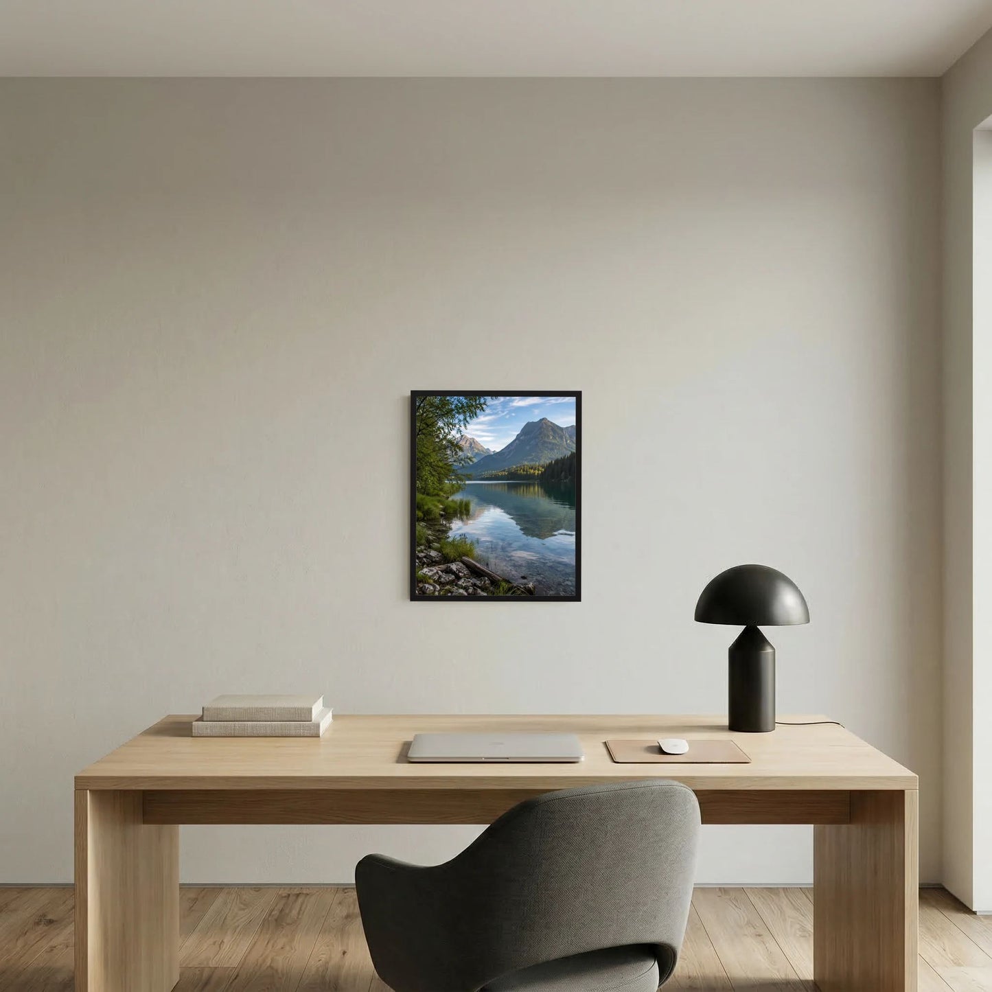 Wandbild im schwarzen Rahmen über Holztisch: Bergsee mit Uferfelsen und Bergen