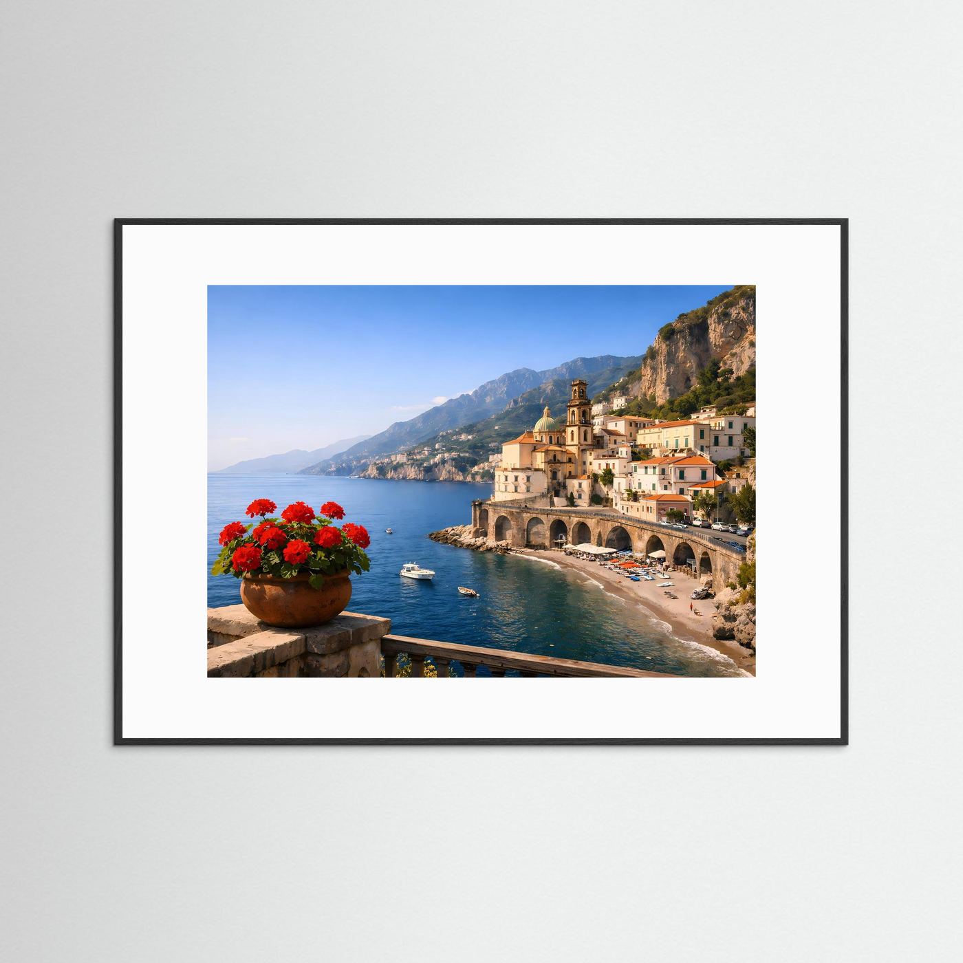 Panorama-Poster im schwarzen Rahmen: Küstenort mit Kirche, Bögen, Strand und roten Blumen.