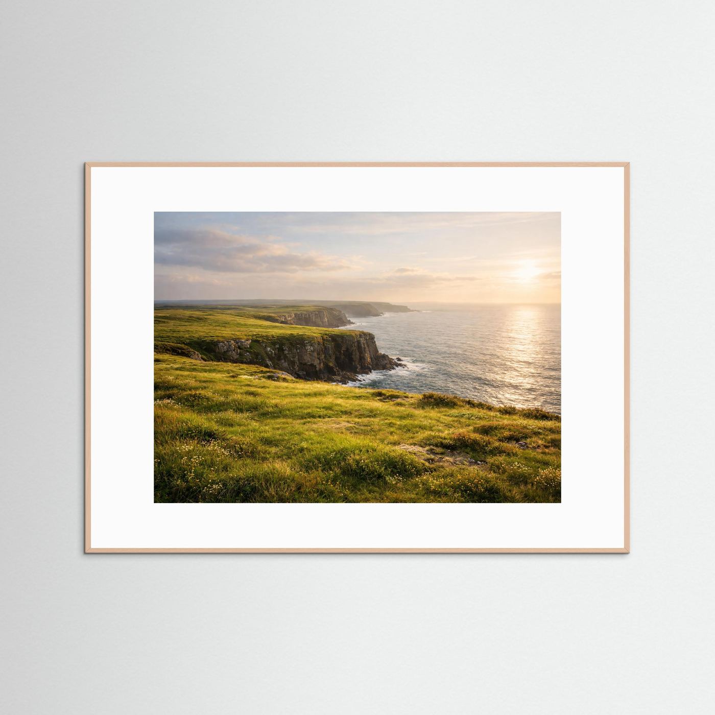 Poster mit grünen Küstenklippen und Meer bei Sonnenuntergang, im beigen Holzrahmen