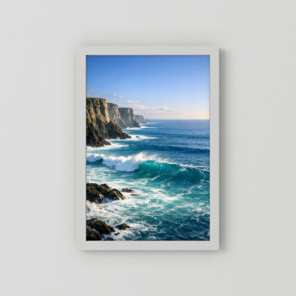 Wandbild im Hochformat mit Steilküste und tosenden Wellen, weißer Rahmen