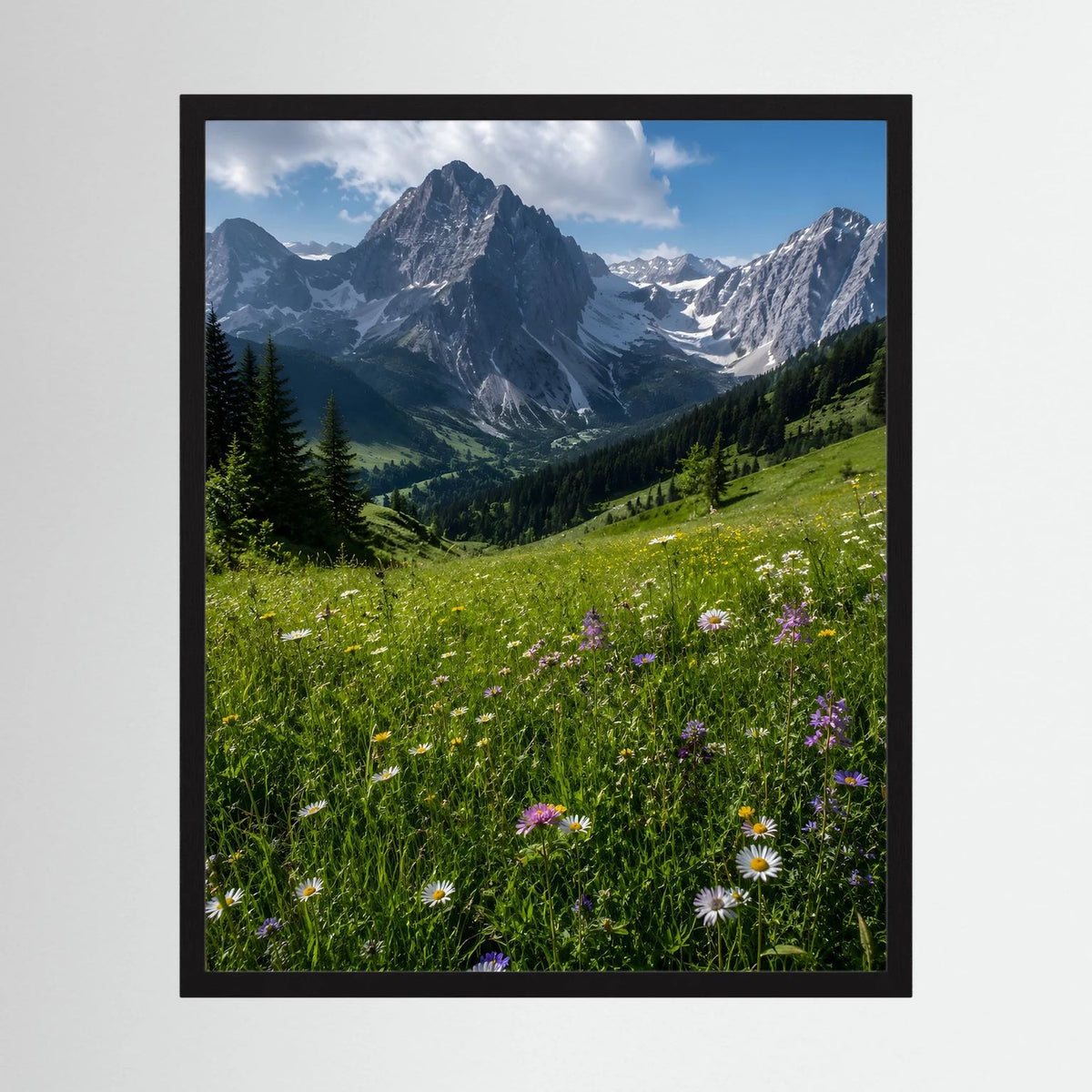 Wandbild im schwarzen Rahmen mit Alpenbergen und Wiesenblumen im Hochformat