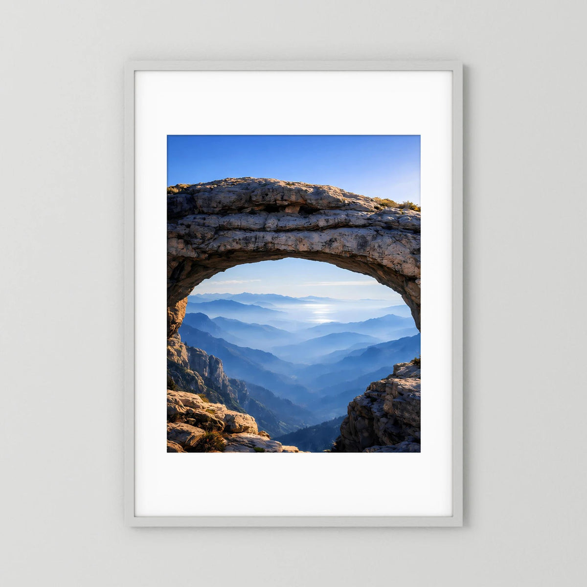 Gerahmtes Poster mit Felsbogen und Bergpanorama, weißer Rahmen im Hochformat