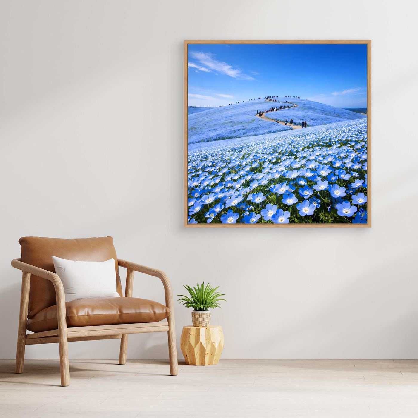 Leinwandbild mit blauem Blütenmeer und Hügelpfad, mit hellem Holzrahmen im Querformat