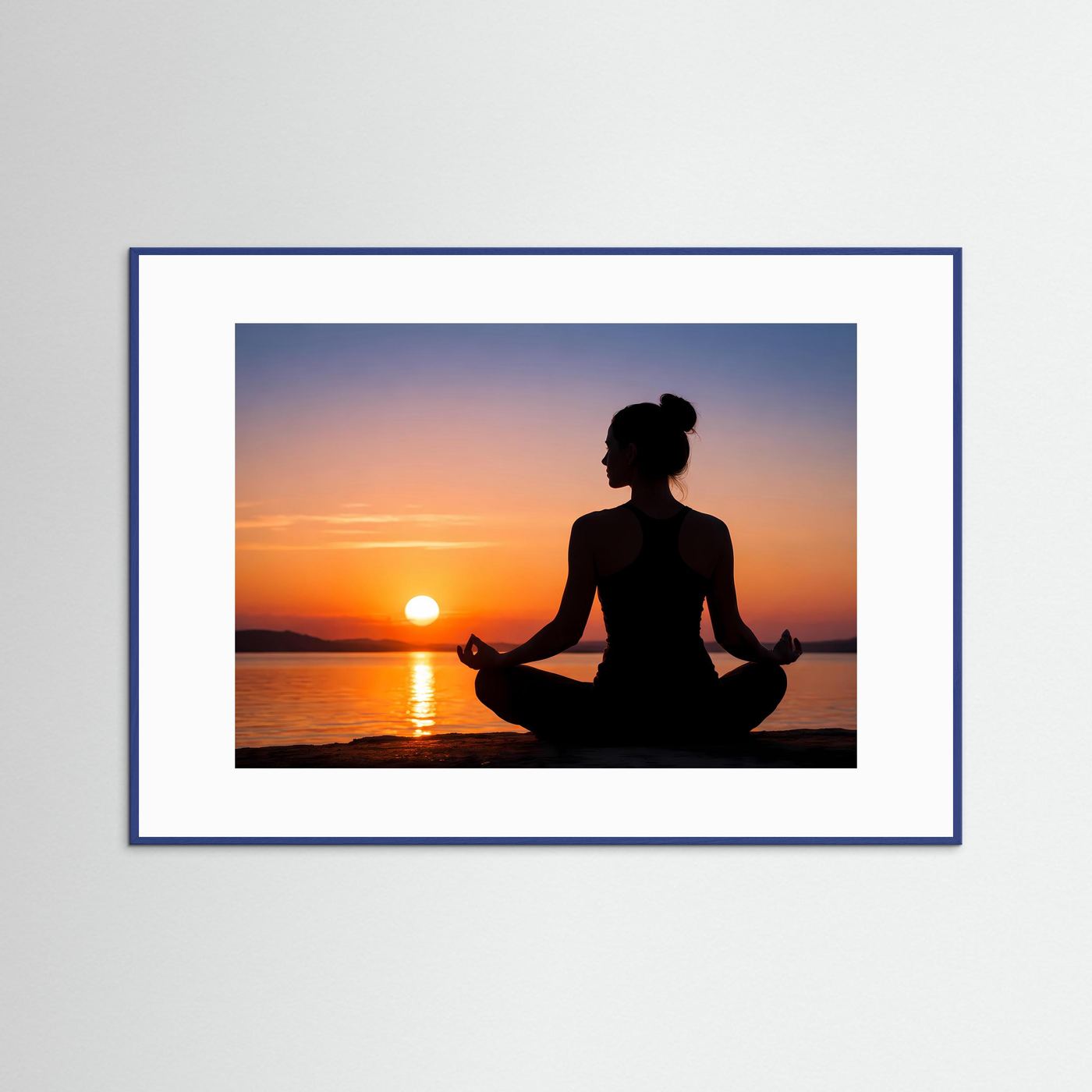 Meditations-Wandbild: Yogafrau-Silhouette im Lotussitz am Sonnenuntergang, blauer Rahmen mit weißem Rand.